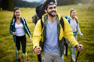 Backpacking Tips for Beginners by PTT Outdoor, PTT Outdoor, group of hikers walking on a mountain and smiling A8QM735,