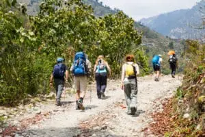 How to protect yourself from the sun while being outdoors?, PTT Outdoor, a group of people trekking on dirt road in nepal PFYBHTS,